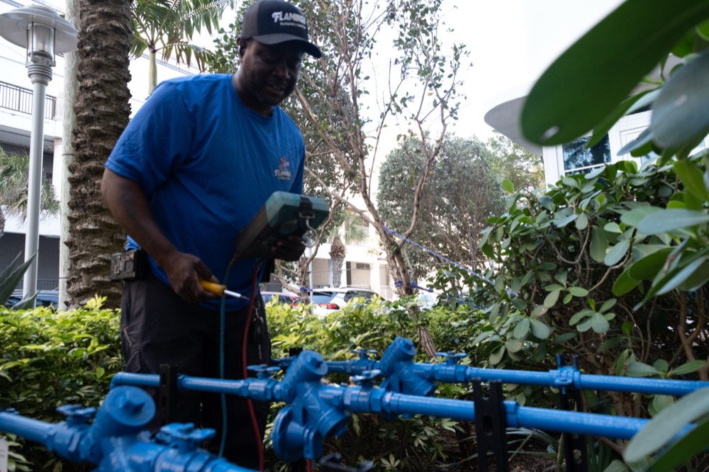 Certified tech connecting a test gauge to a backflow assembly