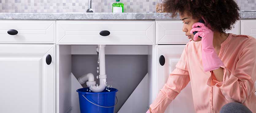 Young Woman Wearing Pink Gloves In Hand Calling Plumber