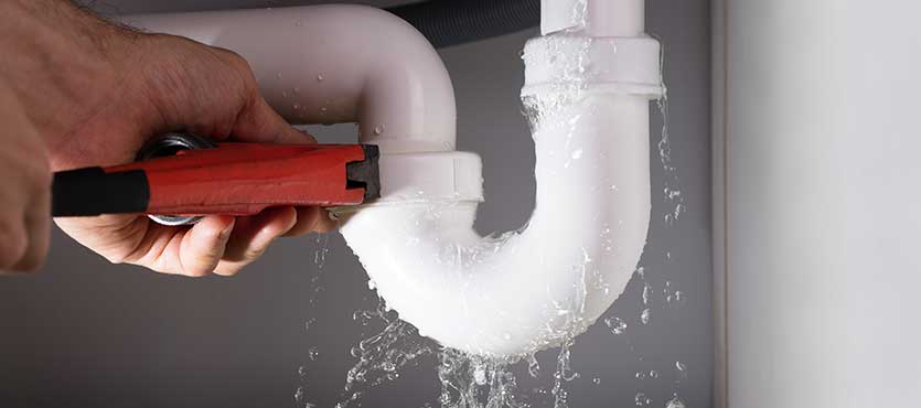 Close-up Of Male Plumber Fixing White Sink Pipe