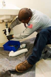 plumber working below a sink